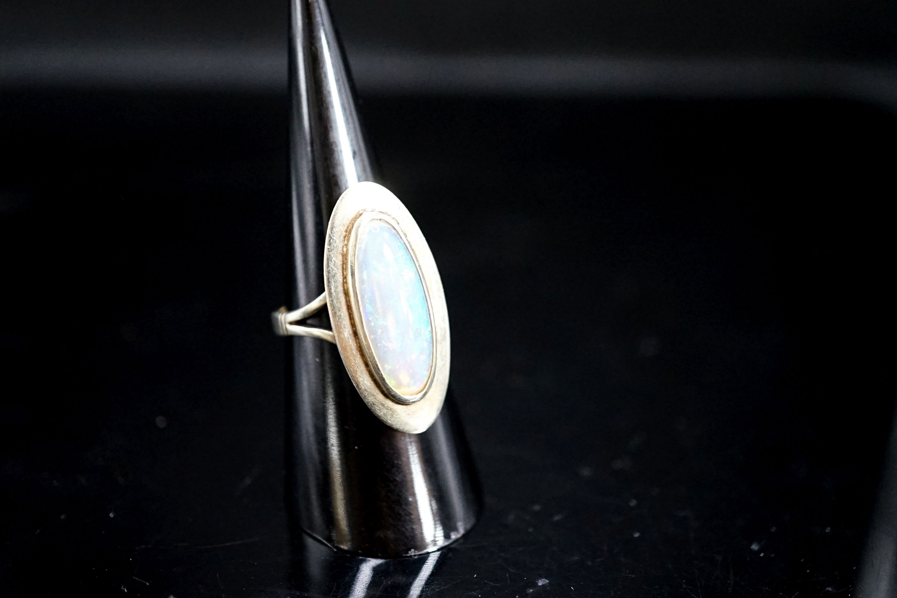 A 9ct white gold and oval cabochon white opal set dress ring